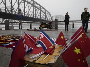 Chinese vendors sell North Korea and China flags on the boardwalk next to the Yalu river in the border city of Dandong, Liaoning province, northern China across from the city of Sinuiju, North Korea on May 24, 2017. (Kevin Frayer/Getty Images)