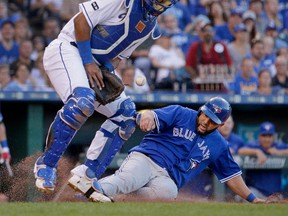 Blue Jays’ Kendrys Morales beats the tag by Royals catcher Salvador Perez to score during their game in Kansas City last night. Morales got a warm reception from his former team. (AP)