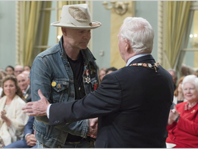 Governor General David Johnston shakes hands with Tragically Hip singer Gord Downie after investing him in the Order of Canada during a ceremony at Rideau Hall, Monday, June 19, 2017 in Ottawa. (Adrian Wyld, The Canadian Press)