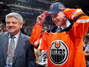 Dmitri Samorukov celebrates after being selected 84th overall by the Edmonton Oilers alongside head coach Todd McLellan during the 2017 NHL Draft at the United Center on June 24, 2017 in Chicago, Illinois.