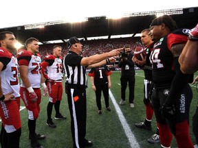 An official conducts the coin toss before the Redblacks took on the Calgary Stampeders on Friday night at TD Place. (THE CANADIAN PRES)