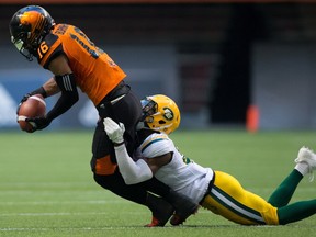 B.C. Lions' Bryan Burnham, left, is tackled by Edmonton Eskimos' Kenny Ladler during the first half of a CFL football game in Vancouver, B.C., on Saturday, June 24, 2017.