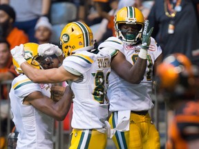 Edmonton Eskimos' Adarius Bowman, from left to right, Brandon Zylstra and D'haquille Williams celebrate Williams' touchdown against the B.C. Lions during the first half of a CFL football game in Vancouver, B.C., on Saturday, June 24, 2017.