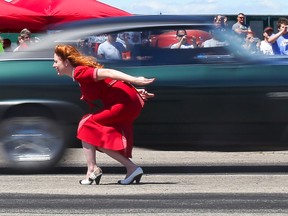 A Monte Carlo thunders past flag girl Miss Mandy Mae during a race at an Armdrop Drag Racing event on Saturday June 24, 2017 in Picton, Ont. Tim Miller/Belleville Intelligencer/Postmedia Network