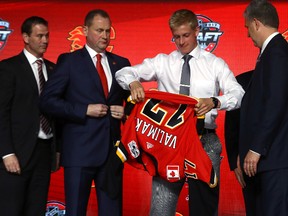Juuso Valimaki puts on the Calgary Flames jersey after being selected 16th overall during the 2017 NHL Draft at the United Center on June 23, 2017 in Chicago, Illinois. (Photo by Bruce Bennett/Getty Images)