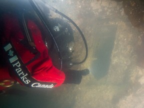 A Parks Canada archaeologist at the stern of the HMS Terror wreck looks through one of the Captain's Cabin windows in a handout photo from October 2016.