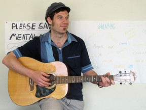 Richard Tyo with the guitar he uses for Musicalize Your Mental Health on Tuesdays at the AMHS-KFLA offices, where he also works as a Transitional Case manager. (Ashley Rhamey/For The Whig-Standard)