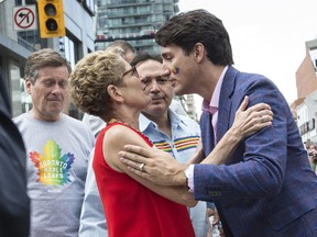 Ontario Premier Kathleen Wynne and Prime Minister Justin Trudeau share a moment during the Pride parade on Sunday, June 25, 2017. (CRAIG ROBERTSON/TORONTO SUN)