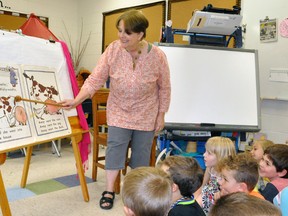 Karen Hocking (right), a kindergarten teacher at Upper Thames Elementary School (UTES), helps her class read a storybook during one of her final days at the school. The longtime teacher will retire at the end of the school year and is unique in that she also was a student at UTES. ANDY BADER/MITCHELL ADVOCATE