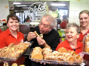 Owner Gus Pantazis is shown in this file photo going in for a prune-filled paczkis at Global Donuts and Deli on London Road in Sarnia, Ont. With him are, from left, Global staff Lisa Serwatkiewicz, Vicky Docktara and Lauren Croskery. Global and Sarnia's Sunripe have made a list of Canada's Favorite Bakeries. (File photo/THE OBSERVER)
