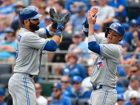 Jose Bautista of the Toronto Blue Jays celebrates his two-run home run with Ryan Goins in the fifth inning against the Kansas City Royals at Kauffman Stadium on June 25, 2017. (Ed Zurga/Getty Images)