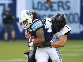 Tiger-Cats’ John Chick ties up the Argonauts’ Declan Cross during the fourth quarter on Sunday. The Argos next see action at home against the Lions on Friday. (Jack Boland/Toronto Sun)