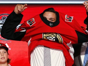 Shane Bowers puts on an Ottawa Senators jersey after being selected by the team during the first round of the NHL hockey draft on June 23, 2017. (AP Photo/Nam Y. Huh)