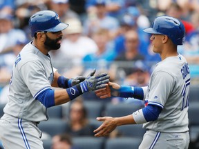 Jose Bautista of the Blue Jays (left) is congratulated by teammate Ryan Goins after hitting a two-run home run in the fifth inning of Toronto’s win on June 25, 2017, over the Kansas City Royals. (COLIN E. BRALEY/AP)