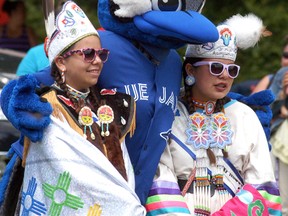 Ace, the Toronto Blue Jays mascot, poses with a pair of dancers at Walpole Island's National Aboriginal Day celebration held on Wednesday, June 21. The Toronto Blue Jays Jays Care Foundation was on hand, as they donated close to $140,000 to help refurbish two ball fields.