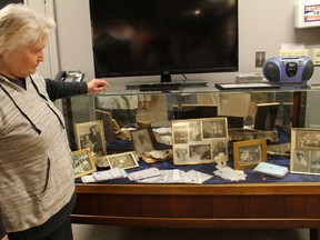 Gunhild Hotte stands beside an exhibit of family photos and letters that are reflected of her families path to this country.