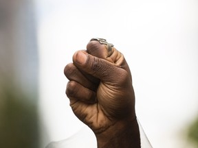 An activist from the Black Lives Matters movement holds up their hand during the Pride Parade in Toronto, Sunday, June 25, 2017. (THE CANADIAN PRESS/PHOTO)