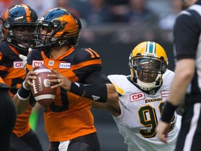 Edmonton Eskimos' Da'Quan Bowers, right, reaches to bring down B.C. Lions' quarterback Jonathon Jennings during the first half of a CFL football game in Vancouver, B.C., on Saturday, June 24, 2017.
