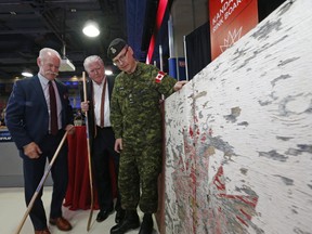 Hockey Hall of Fame chairman Lanny McDonald (left), Calgary Flames president of hockey operations Brian Burke and Brig.-Gen. Kevin Cotton look at the rink boards from Kandahar, Afghanistan, on Tuesday, June 27, 2017. The boards will be on display at the Hockey Hall of Fame this summer. (MICHAEL PEAKE/TORONTO SUN)
