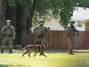 RCMP officers in tactical gear search for a lone male suspect believed to be armed in the north end of Portage la Prairie, Man., on Tuesday, June 27, 2017. Police arrested a male suspect who fled a traffic stop at a local grocery store in Portage and they believe was armed with a rifle. Portage is about 85 kilometres west of Winnipeg. MICKEY DUMONT/Portage Daily Graphic/Postmedia Network