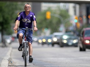 Downtown cycle lanes are being debated at City Hall, in Winnipeg. This cyclist is on Portage Avenue. Tuesday, June 27, 2017. Chris Procaylo/Winnipeg Sun/Postmedia Network