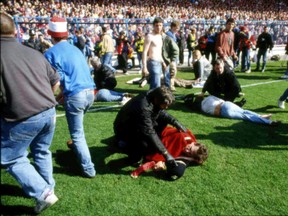 In this April 15, 1989 file photo, police, stewards and supporters tend and care for wounded supporters on the pitch at Hillsborough Stadium, in Sheffield, England. British prosecutors on Wednesday June 28, 2017, are set to announce whether they plan to lay charges in the deaths of 96 people in the Hillsborough stadium crush _ one of Britain’s worst-ever sporting disasters. (AP Photo, File)
