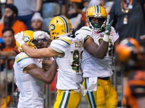 Edmonton Eskimos' Adarius Bowman, from left to right, Brandon Zylstra and D'haquille Williams celebrate Williams' touchdown against the B.C. Lions during the first half of a CFL football game in Vancouver, B.C., on Saturday, June 24, 2017.