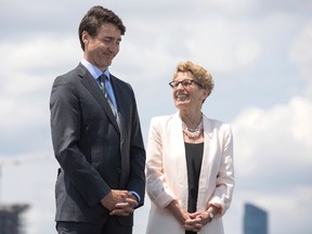 Canadian Prime Minister Justin Trudeau stands alongside Ontario Premier Kathleen Wynne (right) during a funding announcement for the Toronto waterfront in Toronto on Wednesday June 28, 2017. (THE CANADIAN PRESS/Chris Young)