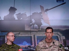 Lieutenant-General Stephen Bowes, left, and Brigadier-General Peter Dawe speak as the Canadian Armed Forces provides an update on Operation IMPACT in the Middle East during a press conference at National Defence headquarters in Ottawa on Thursday, Oct. 6, 2016. Dawe, the deputy commander of Canadian special forces, says the sniper who shattered the record for the longest confirmed kill also saved lives THE CANADIAN PRESS/Sean Kilpatrick