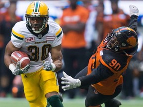 Edmonton Eskimos' John White, left, gets away from B.C. Lions' Mic'hael Brooks during the first half of a CFL football game in Vancouver, B.C., on Saturday, June 24, 2017.