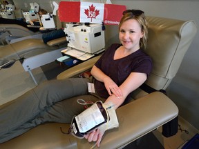 Kelly Caccamo holds a cotton ball on her arm after donating blood Wednesday at the Canadian Blood Services in London. Caccamo came to the clinic with six employees from Columbia Sportswear. (MORRIS LAMONT, The London Free Press)