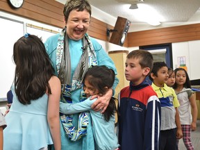 Music teacher Brenda Bracke being hugged by Grade 1 students on June 28, 2017, is saying her final goodbyes to her students at Richard Secord School this week as she gets ready for her last day of teaching before retiring after more than four decades in Edmonton.  Ed Kaiser/Postmedia