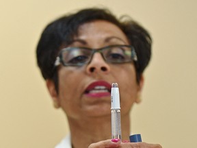 RN Vivien Overall with medication management safety, demonstrates the proper use of an epipen after Dr. Owen Heisler, Chief Medical Officer for Covenant Health notified patients of potential risk of exposure to Hepatitis B and C that stemmed from the demonstration use of these pens, during a news conference at the Grey Nuns Hospital in Edmonton, June 28, 2017. Ed Kaiser/Postmedia