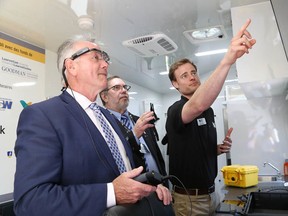 CROSH lab technician Wesley Killen, right, shows Minister of Labour Kevin Flynn, left, and CROSH advisory board chair Leo Gerard thecentre's mobile research laboratory at Laurentian University on Wednesday. (John Lappa/Sudbury Star)