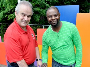 Randy Warden (left), chairperson of London Celebrates Canada, and Dieufert Bellot, director of official languages, drop postcards in a Canada 150 time capsule that will be buried in Harris Park and unsealed in 50 years. (CHRIS MONTANINI\LONDONER\POSTMEDIA NETWORK)