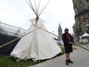 A man stands outside a large teepee erected by indigenous demonstrators to kick off a four-day Canada Day protest in front of Parliament Hill in Ottawa on Thursday, June 29, 2017. Justin Tang, CP