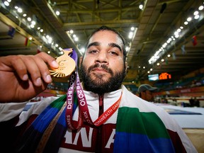 Arjan Bhullar of Canada poses with his gold medal after winning the men's 120kg freestyle gold medal wrestling event against Joginder Kumar of India at IG Sports Complex during the Commonwealth Games on Oct. 10, 2010. (Cameron Spencer/Getty Images)
