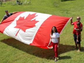 Don Graves, with his wife Donna, son Aaron, left, and grandson Riley at Graves' east Kingston home with a Canadian flag that flew on the Peace Tower on April 9 this year. (Ian MacAlpine/The Whig-Standard)