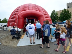 Audience members head into the SESQUI Dome set up in the Budweiser Gardens parking lot to watch a film Thursday about Canada.  (MORRIS LAMONT, The London Free Press)