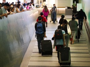 Travelers make their way up the arrival ramp at the Tom Bradley International Terminal at the Los Angeles International Airport on Thursday, June 29, 2017. (AP Photo/Jae C. Hong)