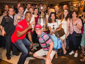 Henry Burris and fans pose for a photo with the Grey Cup inside the Maple Leaf Pub in central London on June 30, 2017. (Photo by Jim Ross/CFL)