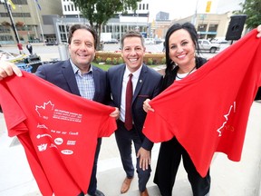 From the left; Downtown Winnipeg BIZ CEO Stephano Grande, Winnipeg's Mayor Brian Bowman, and Winnipeg Sun Director of Advertising Daria Zmiyiwsky promote the living flag on Canada Day, at Portage and Main. Wednesday, June 28, 2017. Chris Procaylo/Winnipeg Sun/Postmedia Network