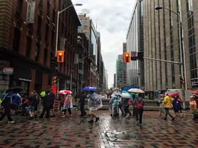 The line up to go through security checks stretches down Bank Street and through an intersection as crowds head to Parliament Hill July 1, 2017. DARREN BROWN / POSTMEDIA