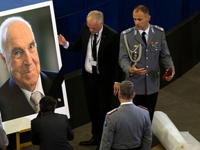 European Parliament employees set up a giant portrait of former German chancellor Helmut Kohl before an European ceremony in Strasbourg, eastern France, Saturday Juny 1, 2017.  (AP Photo/Michel Euler)
