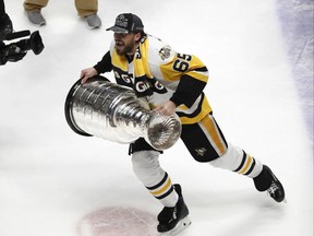 Pittsburgh Penguins' Ron Hainsey (65) hoists the Stanley Cup after defeating Nashville Predators in the NHL hockey Stanley Cup Final on June 11, 2017. (AP PHOTO)
