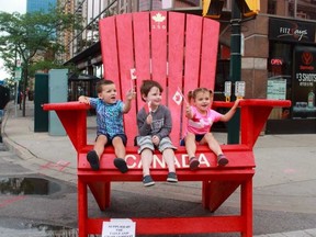 Luke (3), Oakes (4) and Georgia (4) Bowers say happy birthday to Canada at SesquiFest in downtown London on Saturday. (Shalu Mehta/The London Free Press).