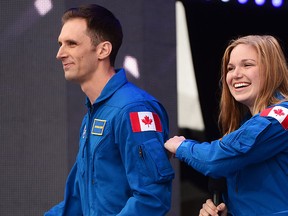 Canada's newest astronauts Joshua Kutryk and Jennifer Sidey acknowledge the crowd during Canada 150 celebrations on Parliament Hill in Ottawa on Saturday, July 1, 2017. THE CANADIAN PRESS/Sean Kilpatrick