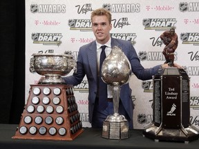 Connor McDavid of the Edmonton Oilers poses with the Art Ross Trophy, left, the Hart Memorial Trophy, center, and the Ted Lindsay Award after winning the honors during the NHL Awards, Wednesday, June 21, 2017, in Las Vegas. (THE CANADIAN PRESS/AP-John Locher)
