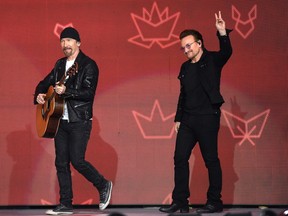 The Edge, left, and Bono from U2 wave to the crowd as they walk onto the stage for a Canada Day performance in Ottawa on Saturday.