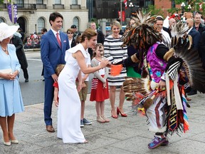 Sophie Grégoire Trudeau, wife of the prime minister, receives a feather from an Indigenous performer during Canada Day celebrations in Ottawa on Saturday.